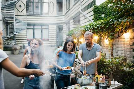 Junge Menschen grillen unbeschwert zusammen in einem Hinterhof