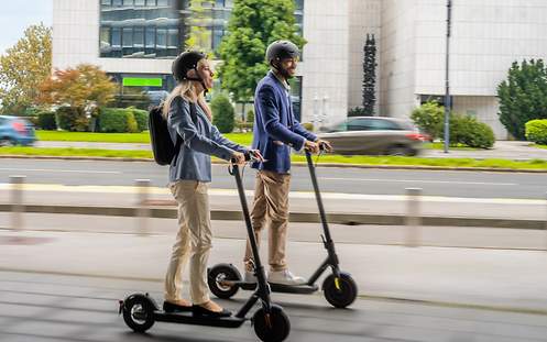 Eine Frau fährt auf einem E-Scooter.